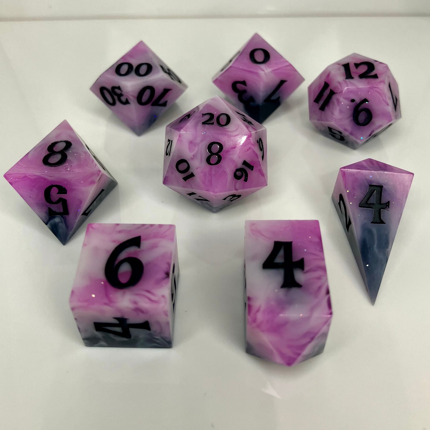 dnd dice set fades from smokey black to pink