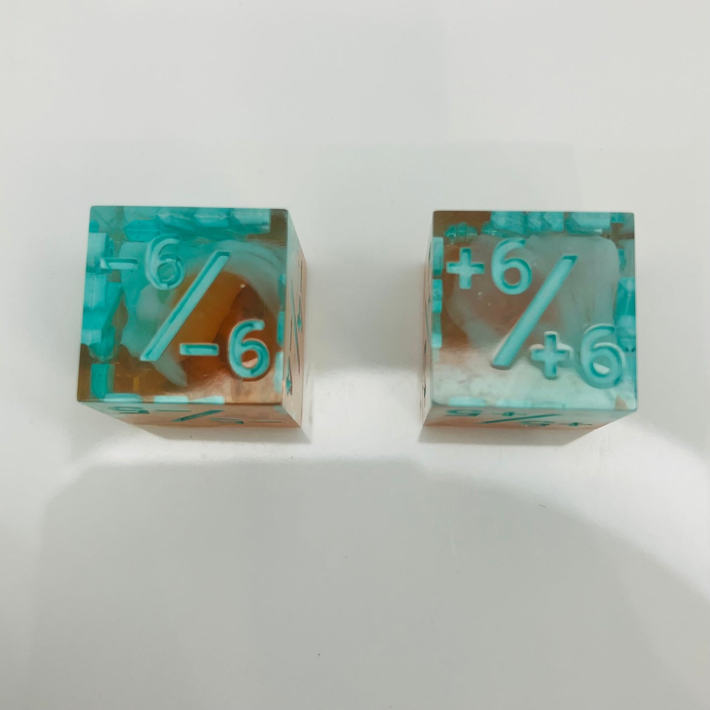 Two transparent dice with blue numbers and a teal to orange gradient