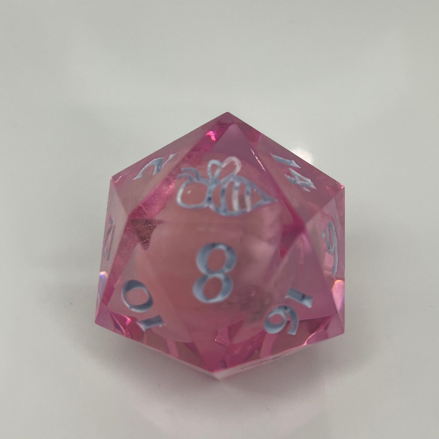 clear pink d20 with bee logo and 'moon' insert