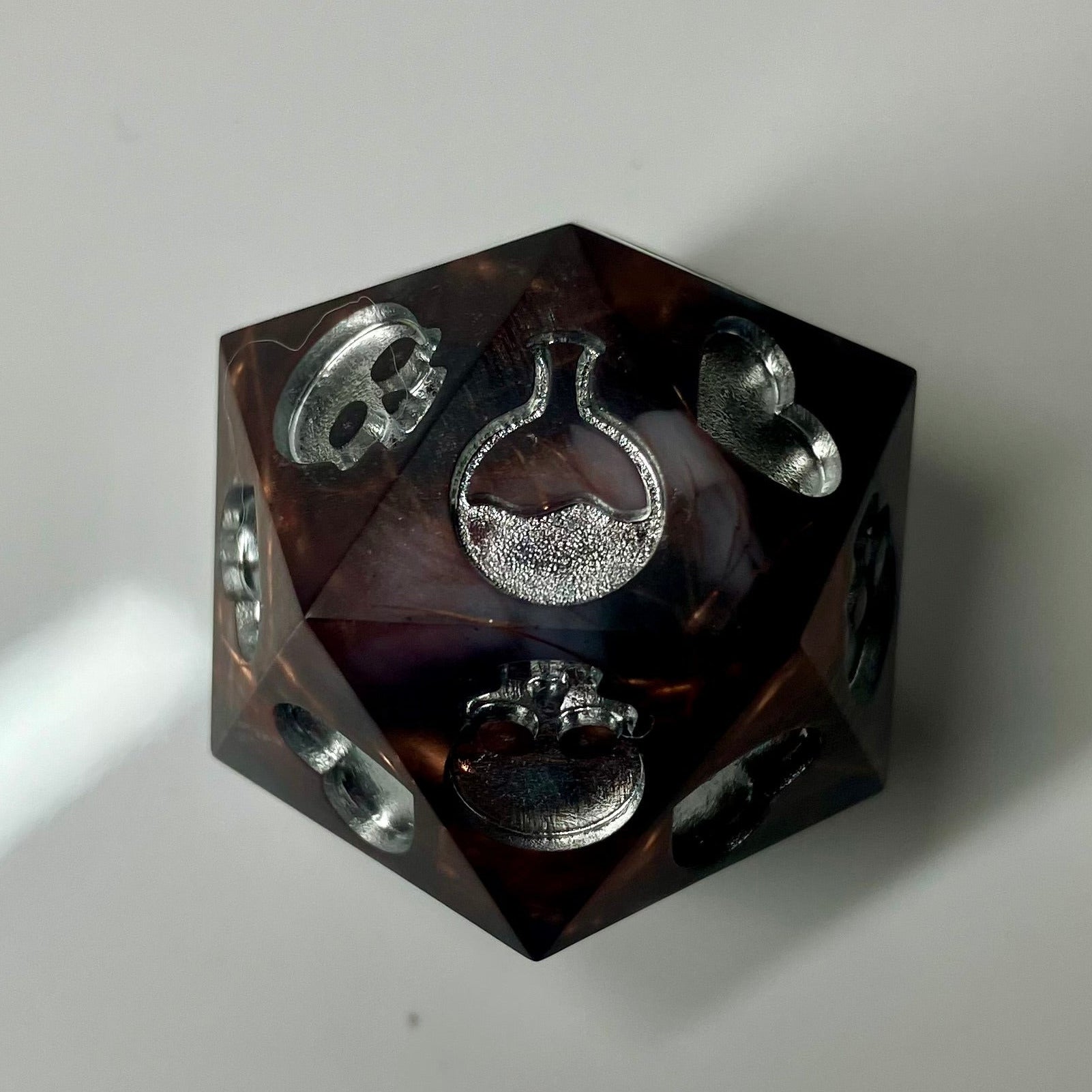 Copper, marble and silver come together in this hand made d20