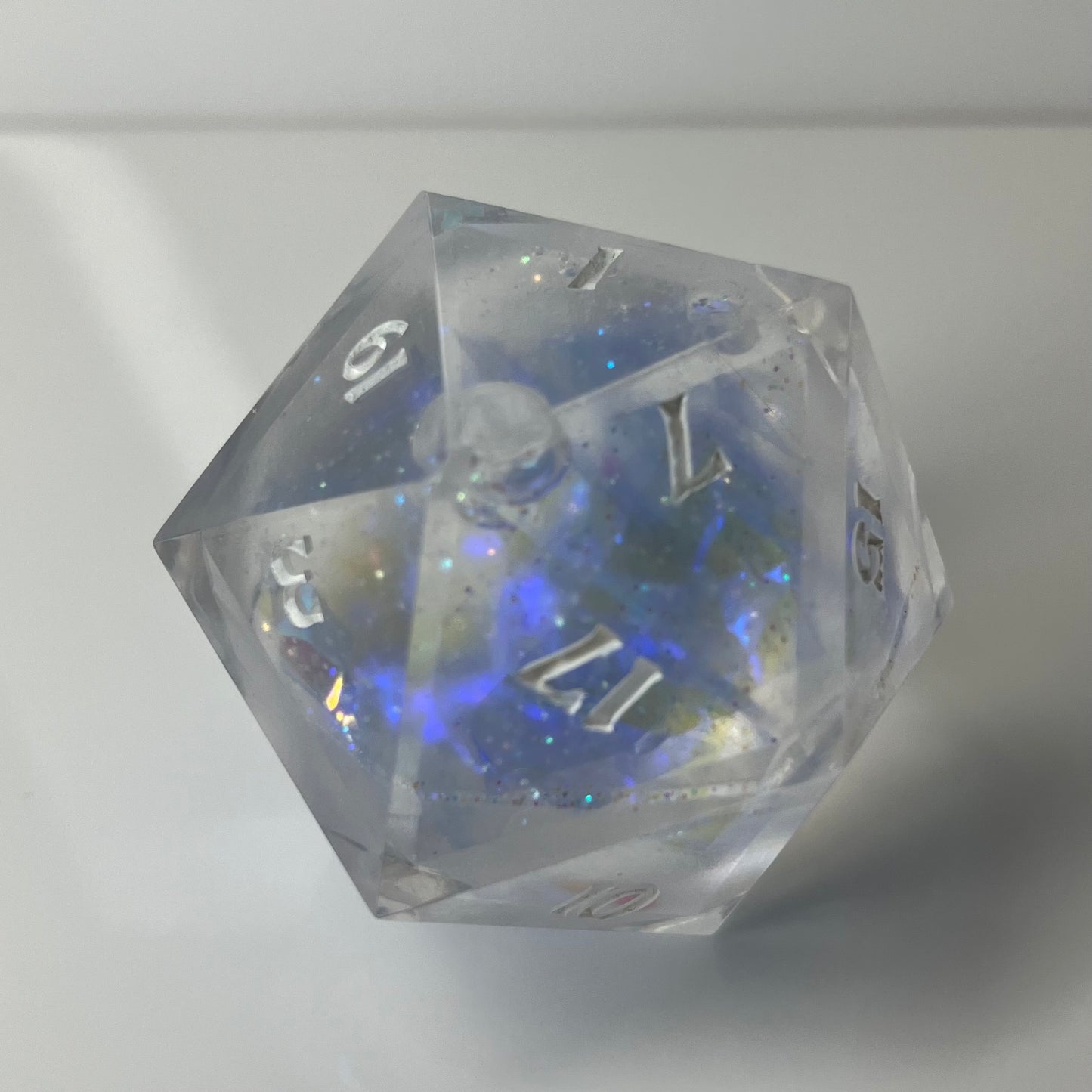 Clear 30mm d20 chunk liquid core with blue glowing opal like glitter