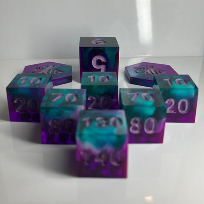 Set of purple and teal polyhedral dice with white clouds for Pokemon TCG