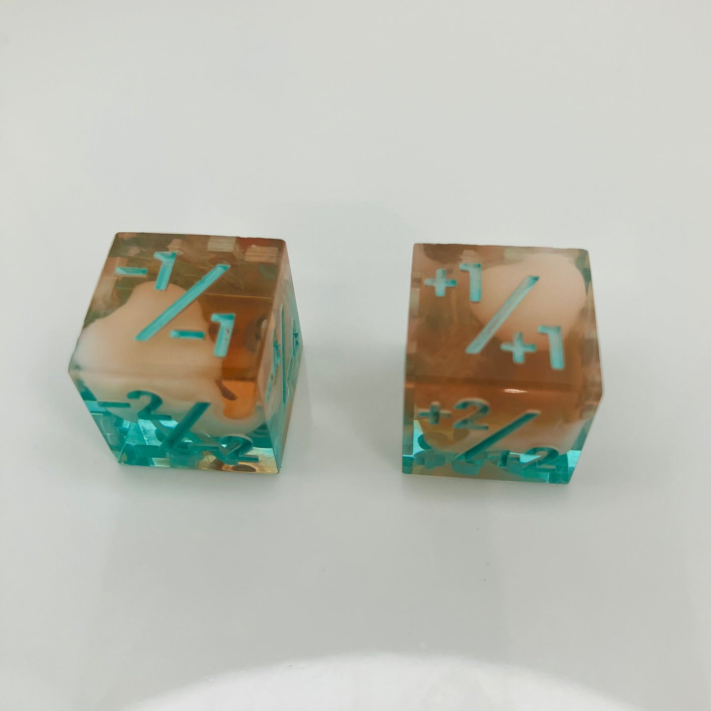 Two transparent dice with blue numbers and a teal to orange gradient