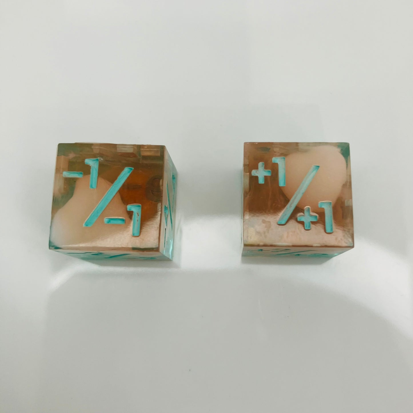 Two transparent dice with blue numbers and a teal to orange gradient