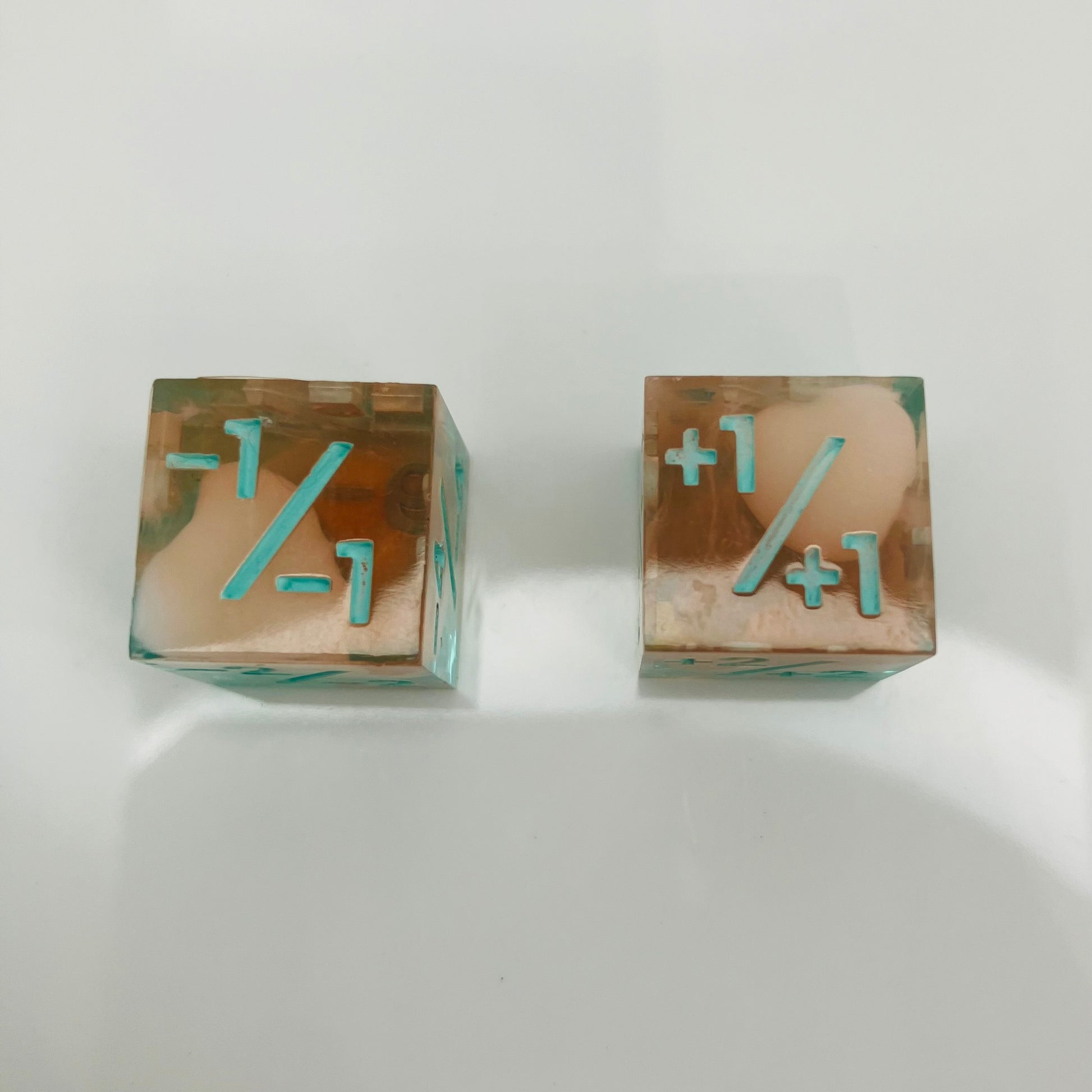 Two transparent dice with blue numbers and a teal to orange gradient