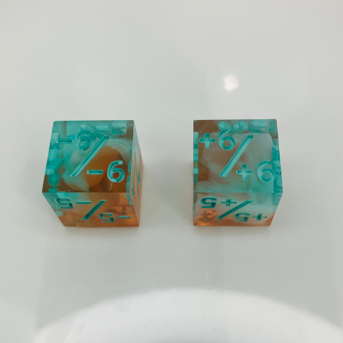 Two transparent dice with blue numbers and a teal to orange gradient