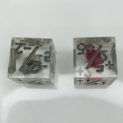 Two clear dice with black numbers with an embedded skull and heart