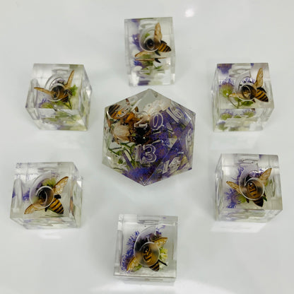 Set of crystal dice with embedded bees and flowers on a white background