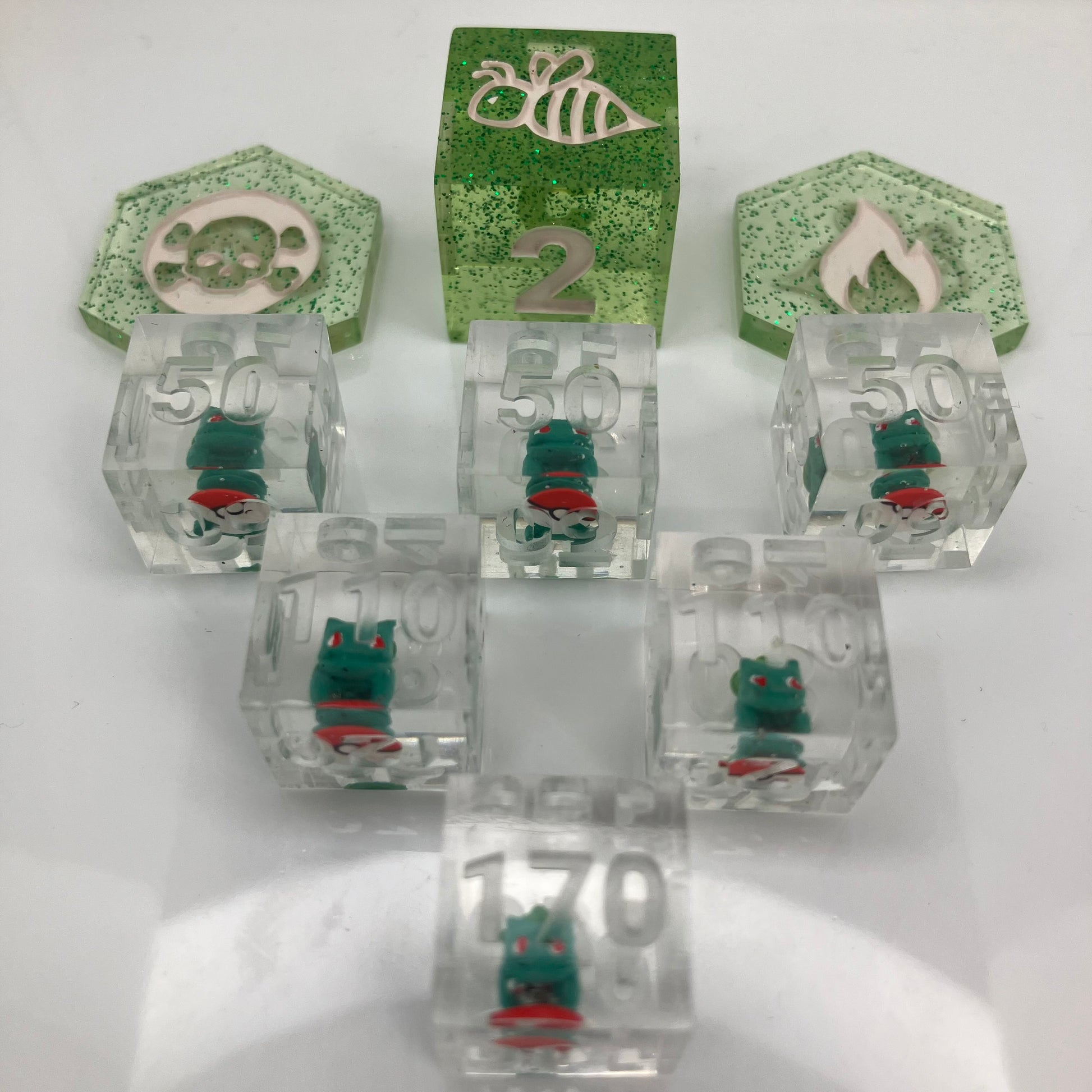 tiny hand painted bulbasaurs set in clear dice for the pokemon trading card game