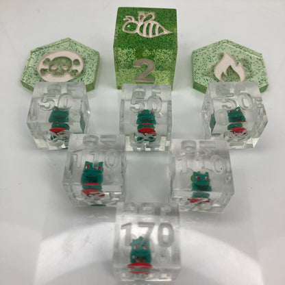 tiny hand painted bulbasaurs set in clear dice for the pokemon trading card game
