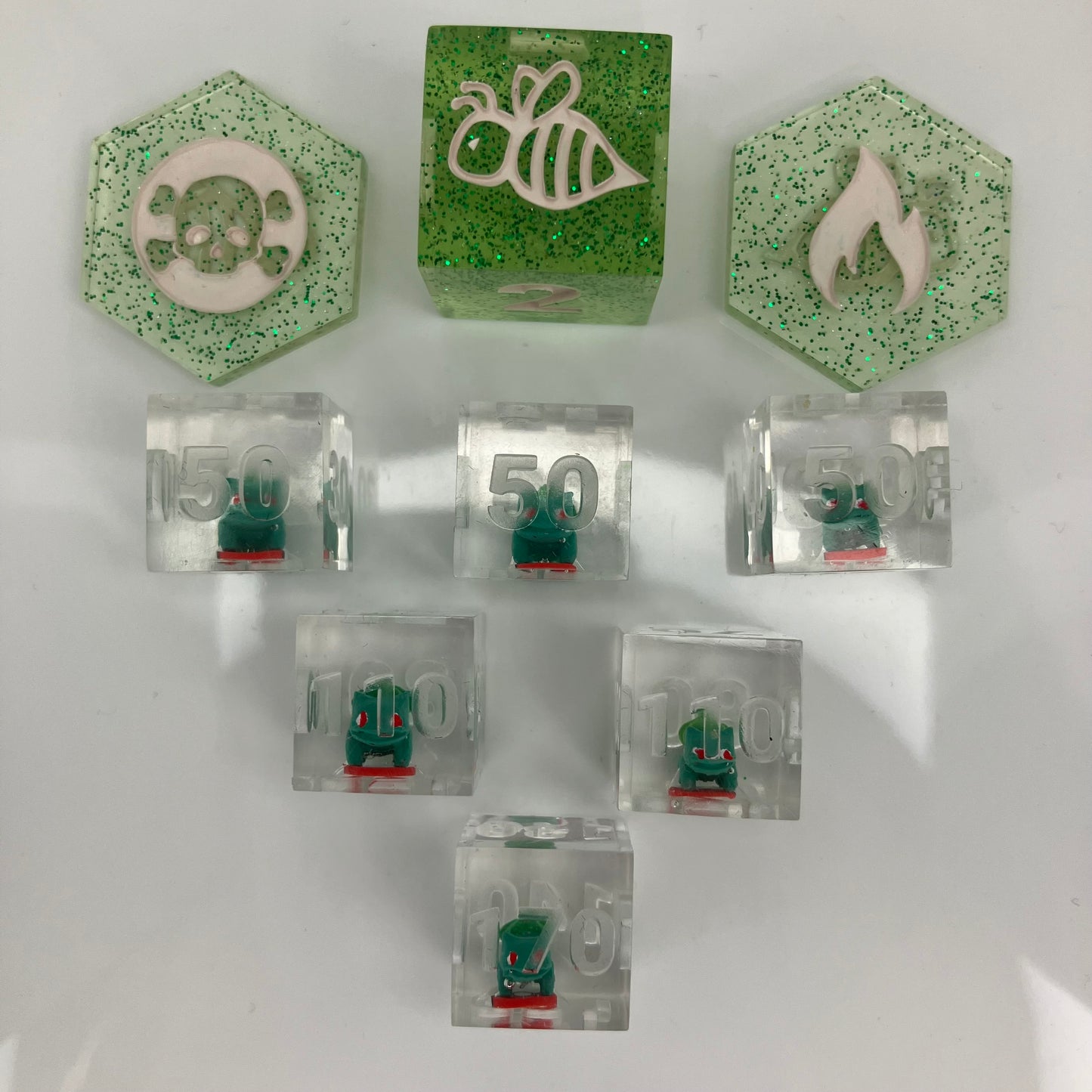 tiny hand painted bulbasaurs set in clear dice for the pokemon trading card game