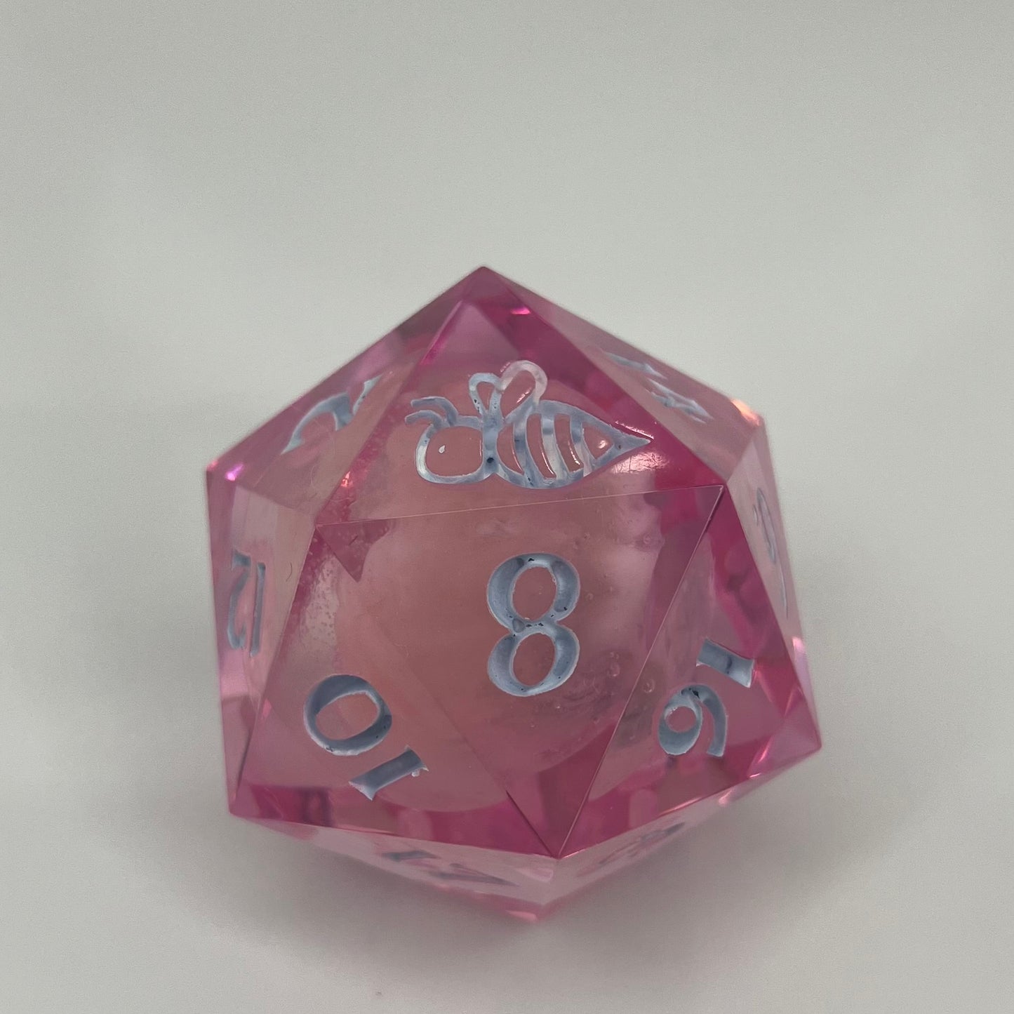 clear pink d20 with bee logo and 'moon' insert