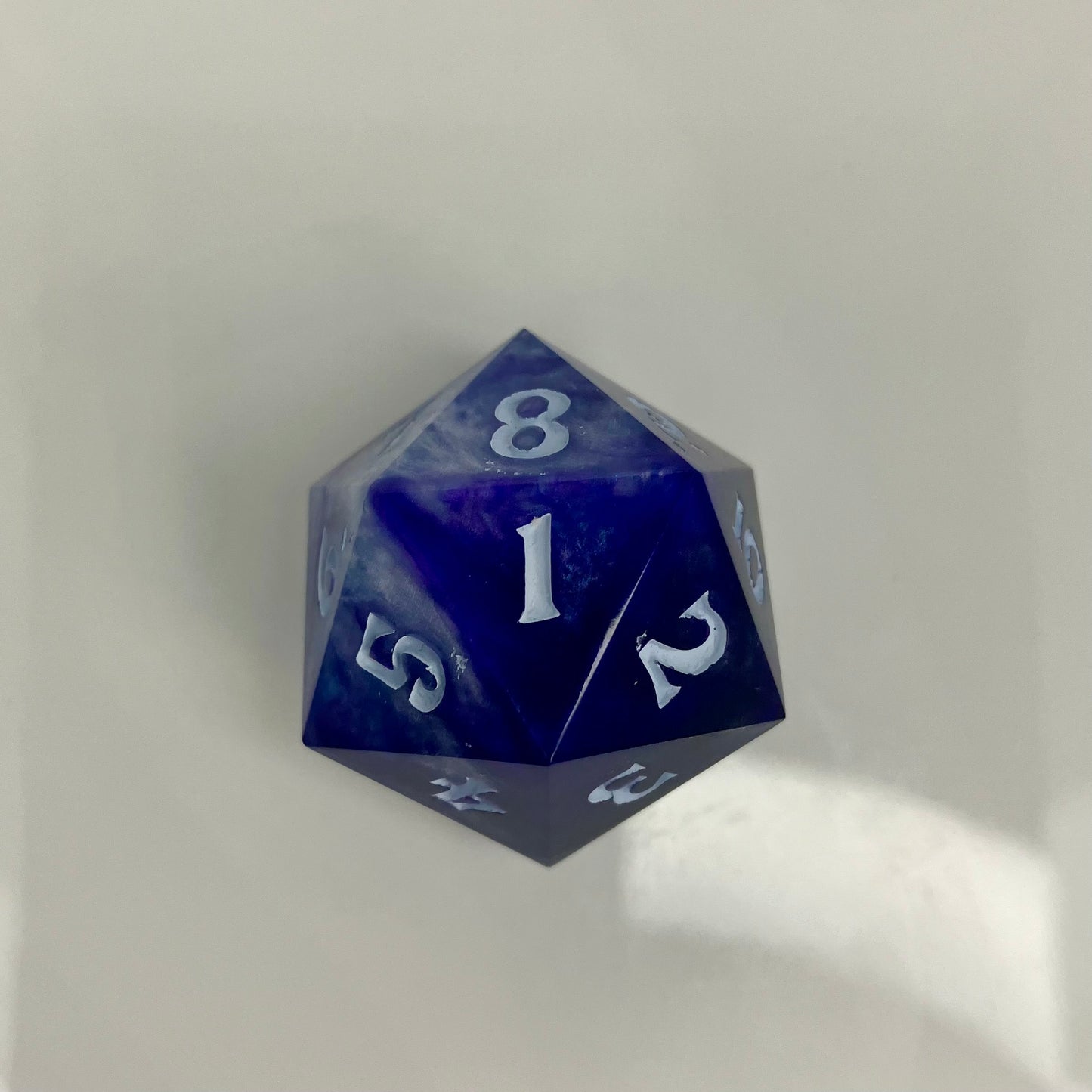indigo and blue with silver swirls cast in a spindown d20