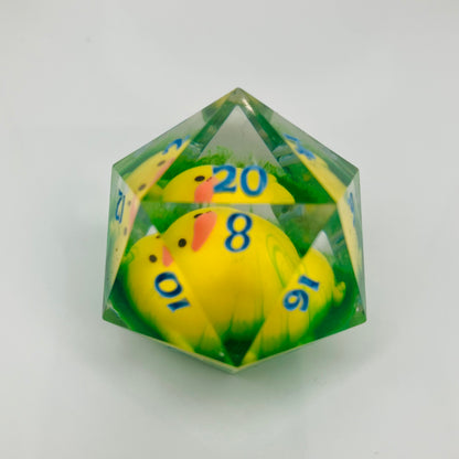 Yellow ducky laying on hand painted grass in a d20 chonk